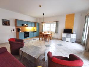 a living room with a table and chairs and a kitchen at BERNSTEINHAUS in Zingst barrierefreie 2-Raum-Wohnung mit Terrasse - Nr 1 in Zingst