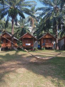 a hammock in front of a resort with palm trees at Som PalmGarden in Ko Lanta