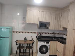 a kitchen with a washer and a sink and a table at playa Almería zapillo loft in Almería