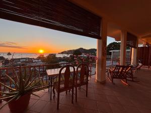 a table and chairs on a balcony with the sunset at Bel Air/Sutton in San Juan del Sur