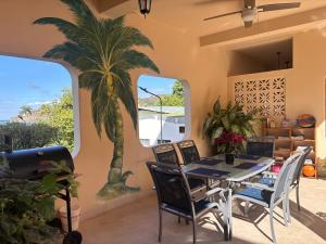 a dining room with a table and chairs and a palm tree at Bel Air/Sutton in San Juan del Sur