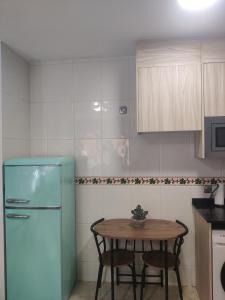 a kitchen with a table and a blue refrigerator at playa Almería zapillo loft in Almería