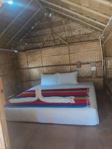 a bedroom with a bed in a straw hut at Som PalmGarden in Ko Lanta