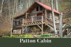 a log cabin in the woods with a red roof at Moore House Inn & Cabins in Marlinton
