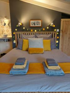 a bed with blue and yellow blankets and pillows on it at Chez Agatha in Vertheuil-en-Médoc