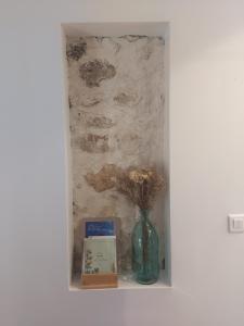 a shelf with a vase with flowers in it at Chez Agatha in Vertheuil-en-Médoc