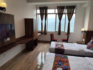 a hotel room with two beds and a flat screen tv at HOTEL GREENERY VIEW in Gangtok