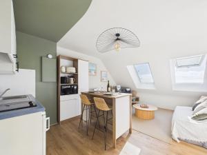 a kitchen with a counter and stools in a room at L îlot d Arthur in Île-Tudy