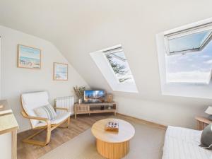 a living room with white furniture and two windows at L îlot d Arthur in Île-Tudy
