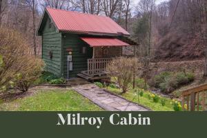 a small green cabin with a red roof at Moore House Inn & Cabins in Marlinton