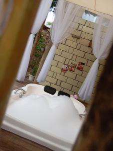 a view of a bath tub in a room at Chalé Orquídea com vista para as montanhas in Palmeiras +23 photos