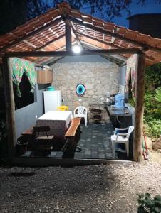 a patio with a table and a refrigerator at Chalé Orquídea com vista para as montanhas in Palmeiras