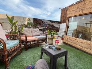 eine Terrasse mit Stühlen und einem Tisch und ein Mann, der auf einer Veranda steht in der Unterkunft panorama villa boutique HT in Jericho
