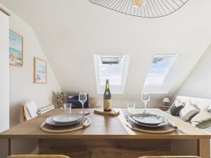 a dining room with a table with a bottle of wine at L îlot d Arthur in Île-Tudy