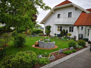 a white house with a garden in the yard at Privatzimmer Helga Haselberger in Ybbs an der Donau