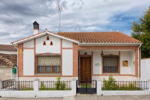 a white and red house with a brown door at Casa rural El Laurel in Chañe