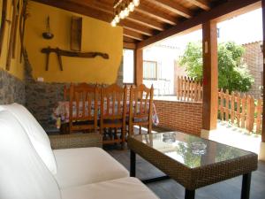 a living room with a table and chairs on a porch at Casa rural El Laurel in Chañe