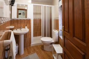 a bathroom with a toilet and a sink and a shower at Apartamentos Carolina in Celorio +37 photos