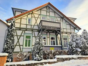 a house with snow covered trees in front of it at Ferienwohnung Berthold WG 3 in Blankenburg