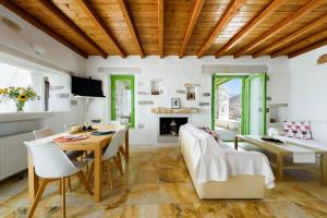 a living room with a table and chairs and a fireplace at Villa Aeolos with 2 private pools in Sarakíniko