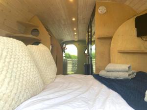 a bedroom with a bed with pillows on it at Highland Gateway Glamping in Clackmannan