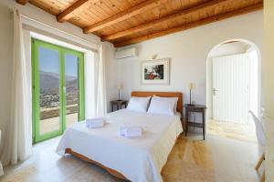 a bedroom with a large bed and a large window at Villa Aeolos with 2 private pools in Sarakíniko +59 photos