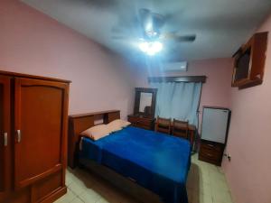 a bedroom with a blue bed and a ceiling fan at Garcia's Suites y Hotel Villegas in Linares
