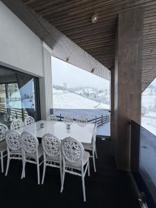 a dining room with a white table and chairs at Sadova Loft View in Sadova