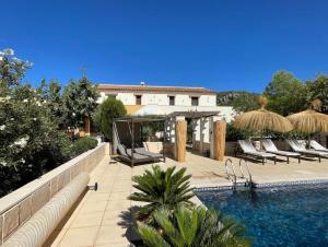a swimming pool with lounge chairs next to a building at B&B Boutique Casa Clavi in Chirivel