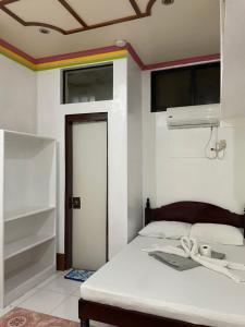 a bedroom with a white bed with a rainbow on the ceiling at Austrias Guest House in El Nido