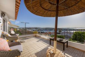 a balcony with an umbrella and a view of the ocean at Casa Flor do Mar Lagos in Lagos