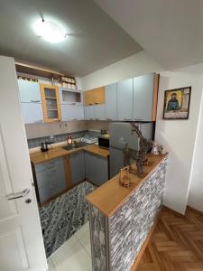 a kitchen with white cabinets and a wooden counter top at Apartman Harmony in Ohrid