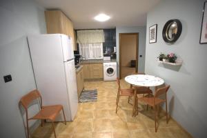a kitchen with a white refrigerator and a table and chairs at Modern Flat in Guejar Sierra in Güéjar-Sierra
