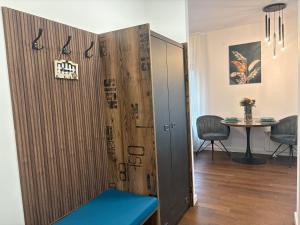 a locker with a blue bench in a room at Azure Living Apartman in Kragujevac