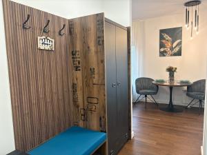 a room with a wooden partition with a blue bench at Azure Living Apartman in Kragujevac