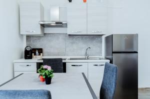 a kitchen with white cabinets and a table and a refrigerator at Tabor Garden near Lake Maggiore by Kibilù Affitti Brevi in Golasecca