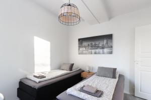 a bedroom with two beds and a chandelier at Pramea Apartments Tourula in Jyväskylä