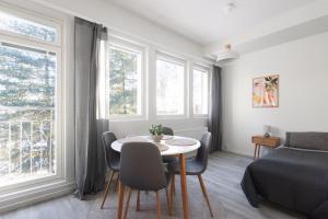 a room with a table and chairs and a bed at Pramea Apartments Tourula in Jyväskylä