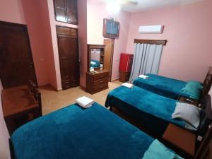 a hotel room with two beds and a mirror at Garcia's Suites y Hotel Villegas in Linares