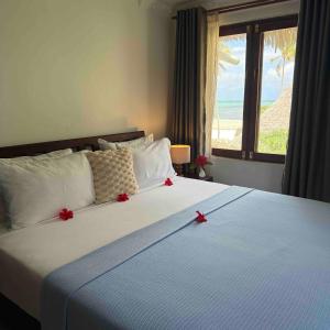 a bedroom with a bed with red bows on it at Amani Palms by Manolo Beach Resort in Uroa