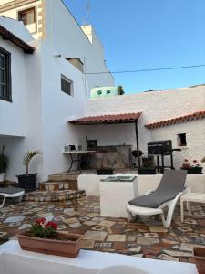 a patio with a table and chairs and a fireplace at Casa Antigua Arona in Arona