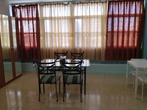 a dining room with a table and chairs and windows at Cádiz bahía in Cádiz