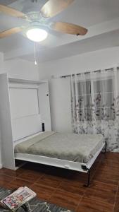 a bedroom with a bed and a ceiling fan at Tim Pappies Nature Lodge - Alex's Place in Port Antonio