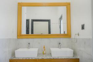 a bathroom with two white sinks and a mirror at Qudrat - Boutique Hostel & Cafe in Bīr