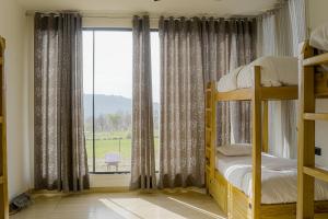 a bedroom with a bunk bed and a large window at Qudrat - Boutique Hostel & Cafe in Bīr +45 photos