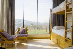 a bedroom with a bunk bed and a large window at Qudrat - Boutique Hostel & Cafe in Bīr