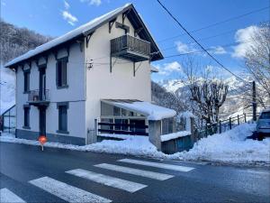 a white building with a balcony on the side of the street at Studio Bareges Le Rioulet 1 in Barèges +2 photos
