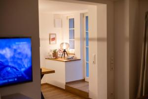 ein Wohnzimmer mit Fernseher und Fenster in der Unterkunft Concordia33 - Traumferienwohnung an der Regnitz in Bamberg