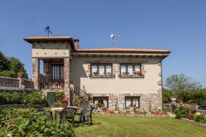 a house with chairs and tables in front of it at Apartamentos Carolina in Celorio