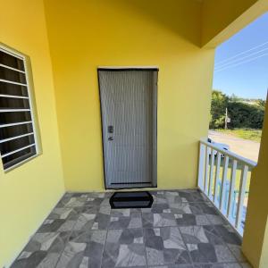 a yellow wall with a door on a balcony at Hector residence in Saint Johnʼs +6 photos